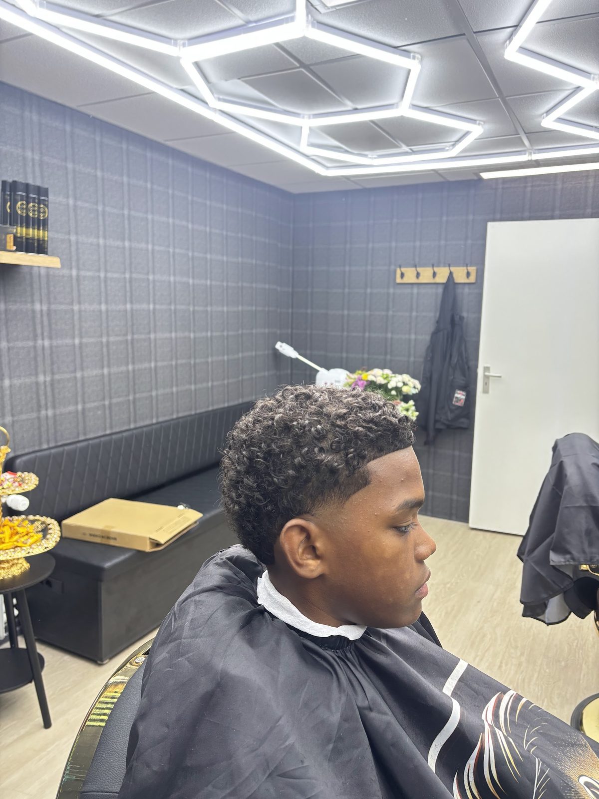 Klant met krullen bovenop en een korte fade opzij
